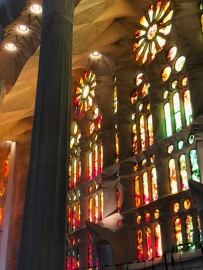 The stained-glass windows from the Passion side reflect reds and oranges through the church